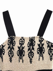 Bohemian smocked maxi dress with black straps and a black tribal pattern on cream fabric.