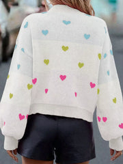 White knit sweater with colorful heart pattern, crew neck, and balloon sleeves.