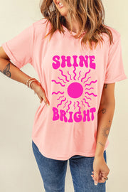 Watermelon pink graphic tee with a retro sunburst and "SHINE BRIGHT" text.