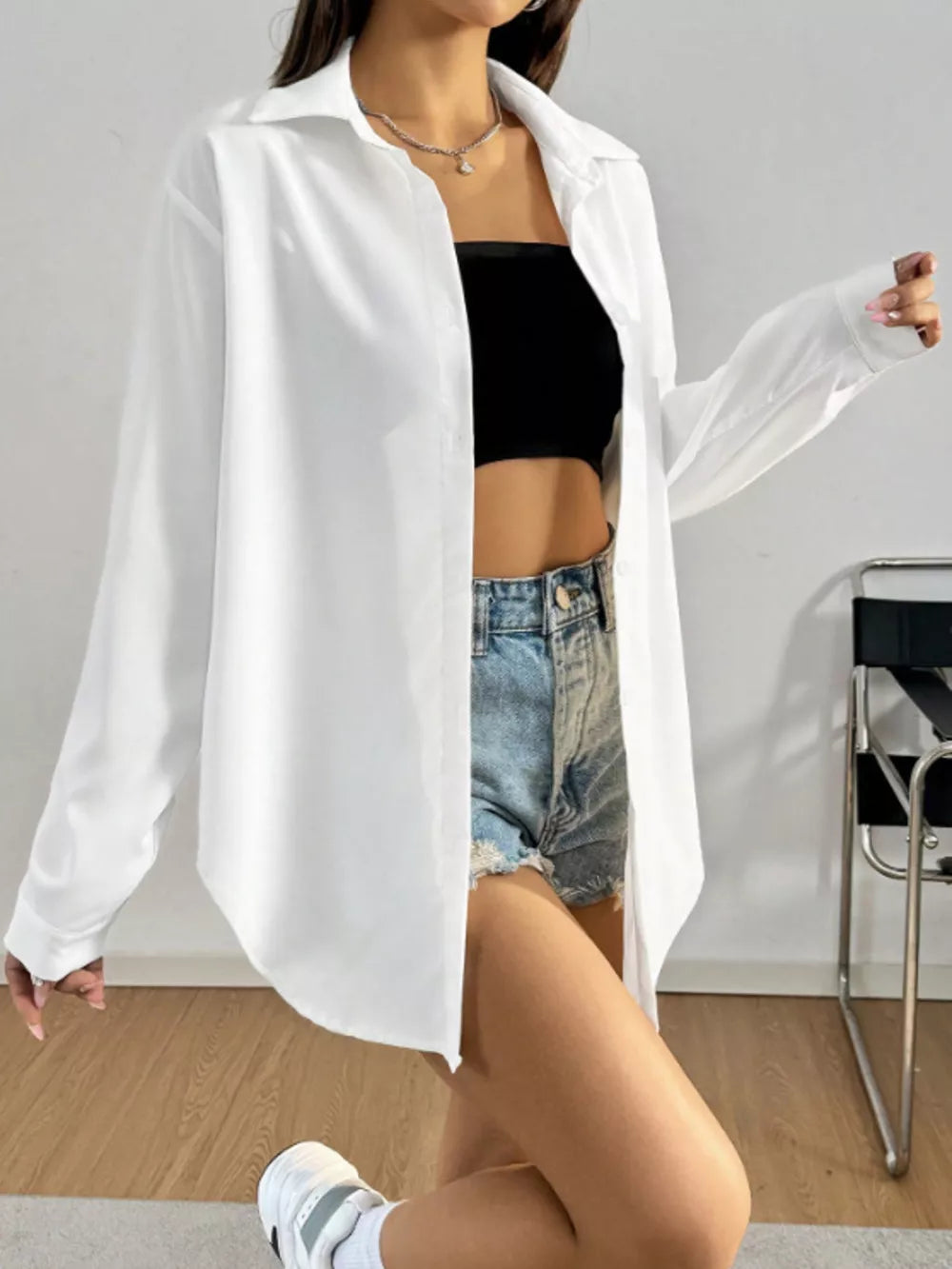 White long sleeve button-up maternity shirt with classic collar, worn open over a black tube top.