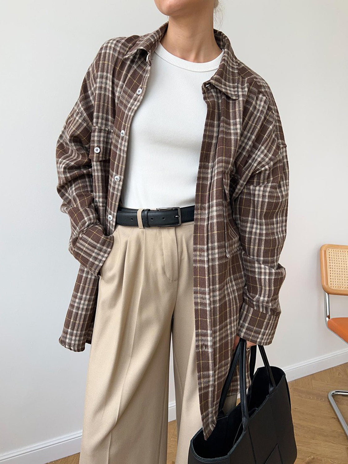 Brown plaid button-up shacket with two chest pockets, worn open over a white top.
