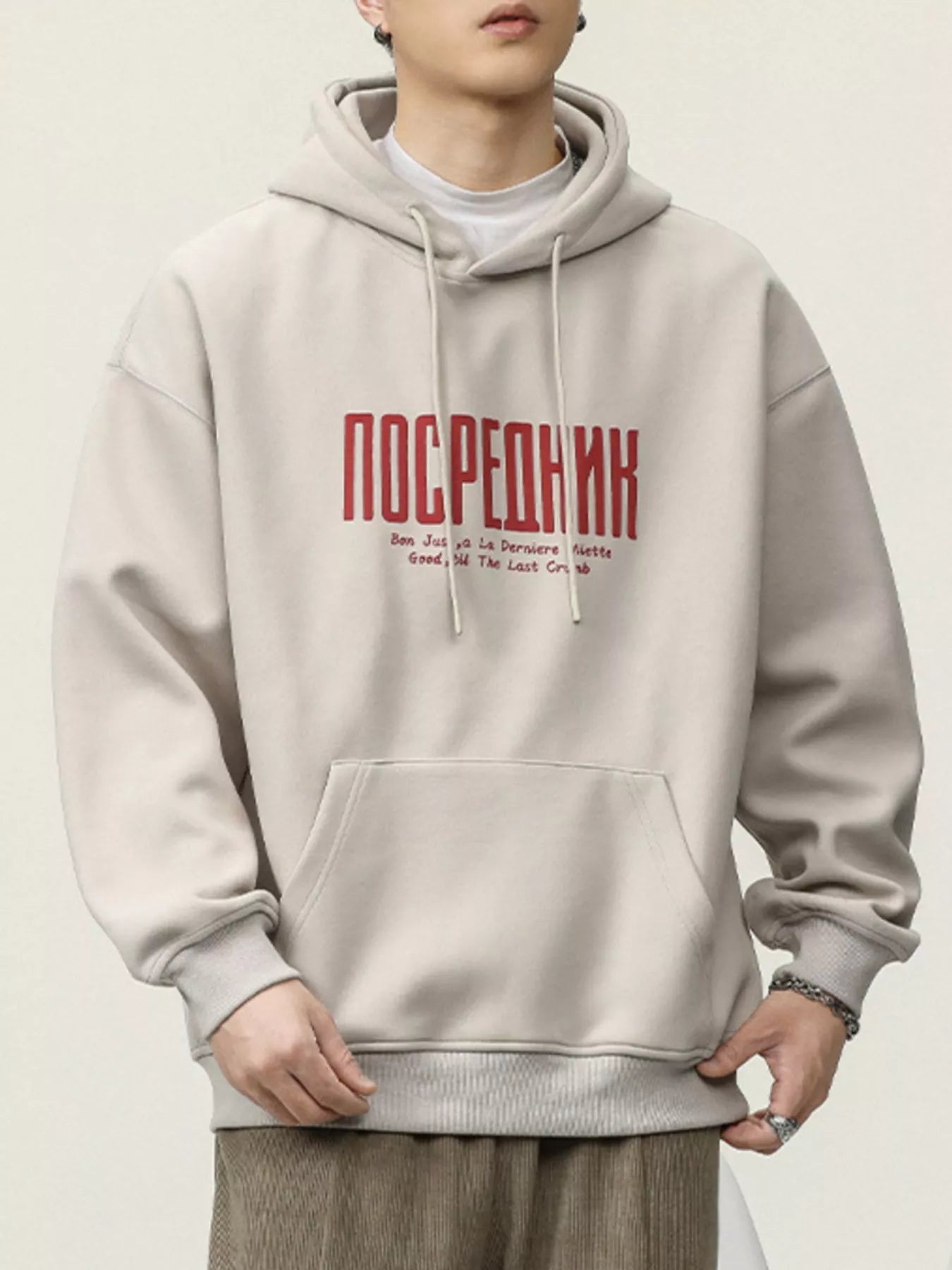Light beige cotton hoodie with red graphic text and drawstring hood.
