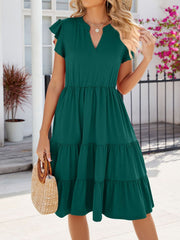 Dark green ruffled midi dress with a notched V-neck and tiered skirt.
