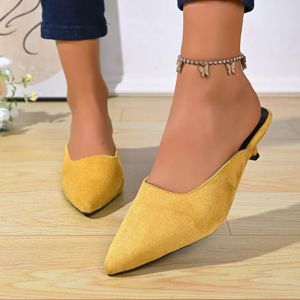 Yellow suede pointed-toe kitten heel mules with butterfly anklet.