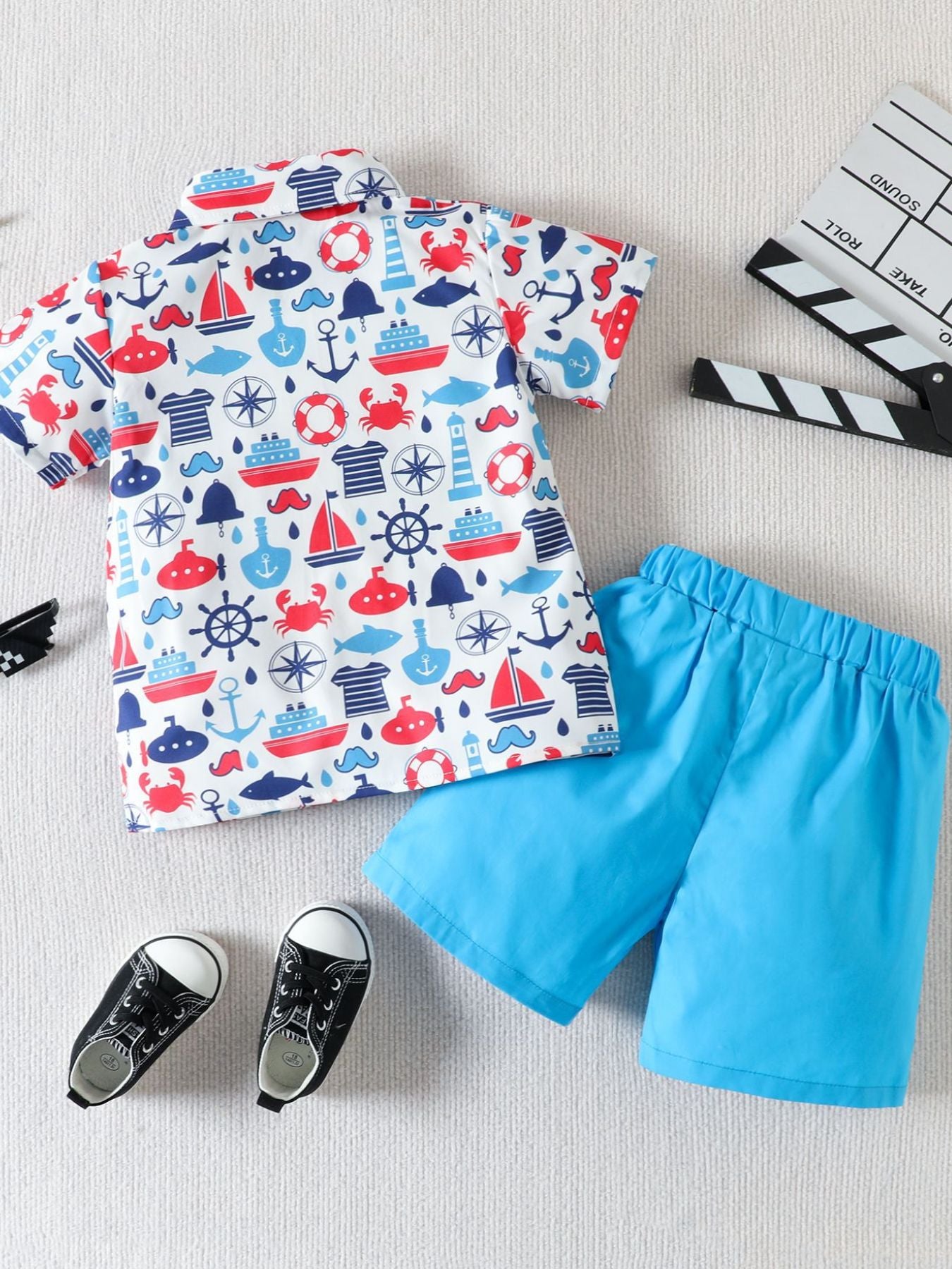 Toddler boys' cotton button-down shirt and shorts set with nautical print and blue shorts.