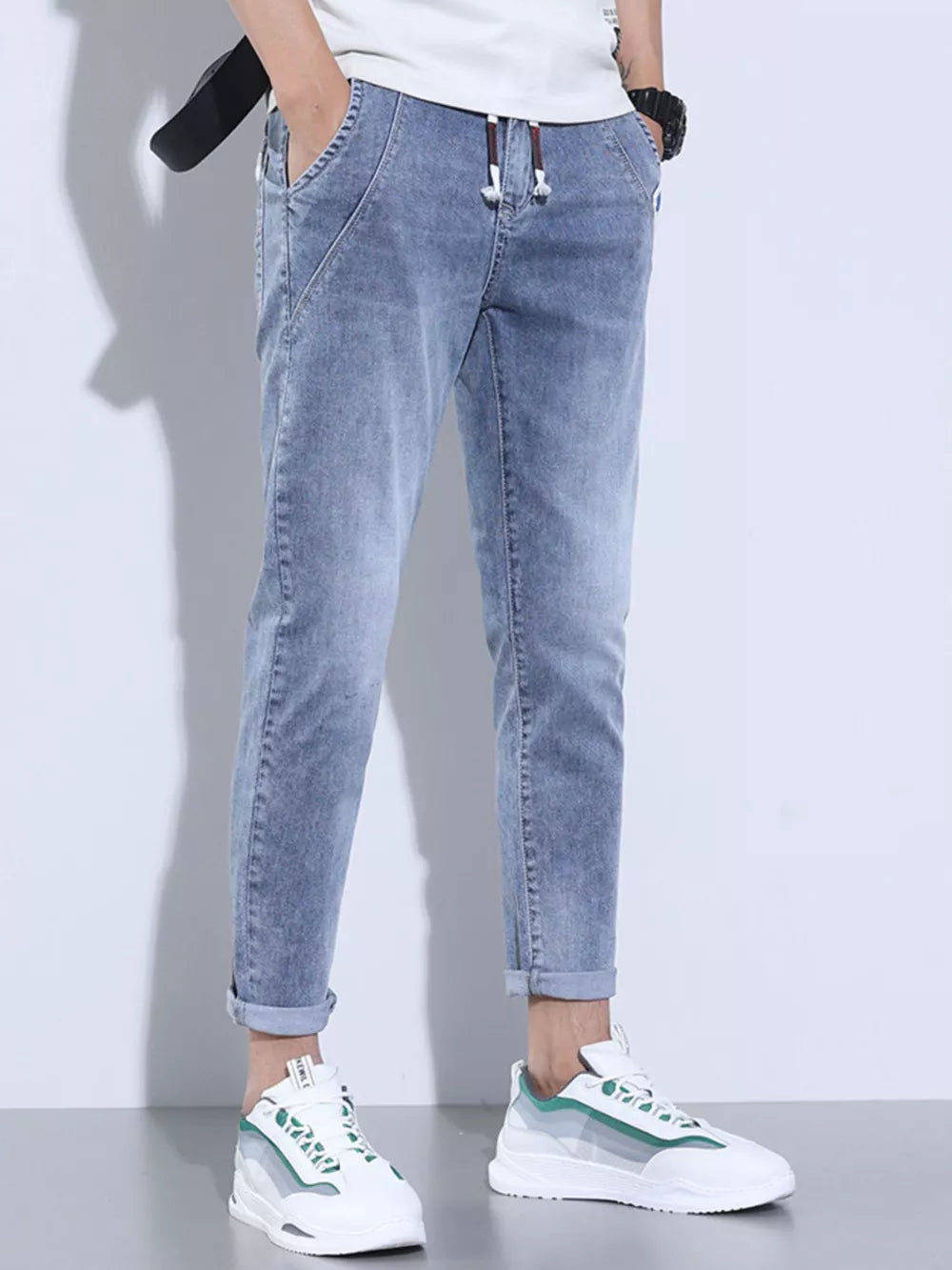 Light blue washed skinny jeans with adjustable drawstring and cuffed ankles.