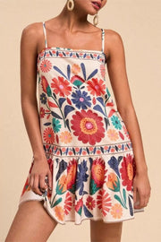 Mini dress with vibrant floral print, square neck, spaghetti straps, and tiered hem.