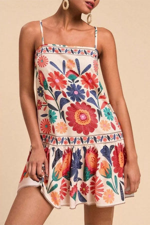 Mini dress with vibrant floral print, square neck, spaghetti straps, and tiered hem.
