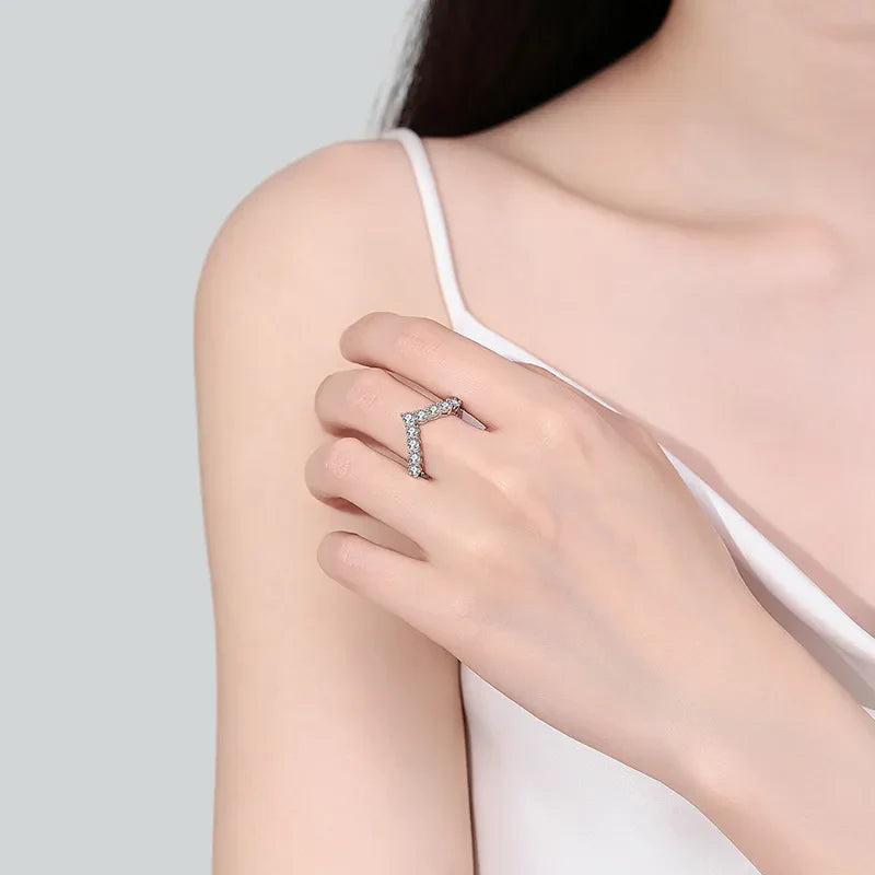 Silver chevron ring with moissanite cluster detail on a woman's hand.