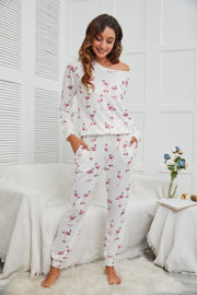 White flamingo print off-shoulder lounge set with long sleeves and elastic waist pants.