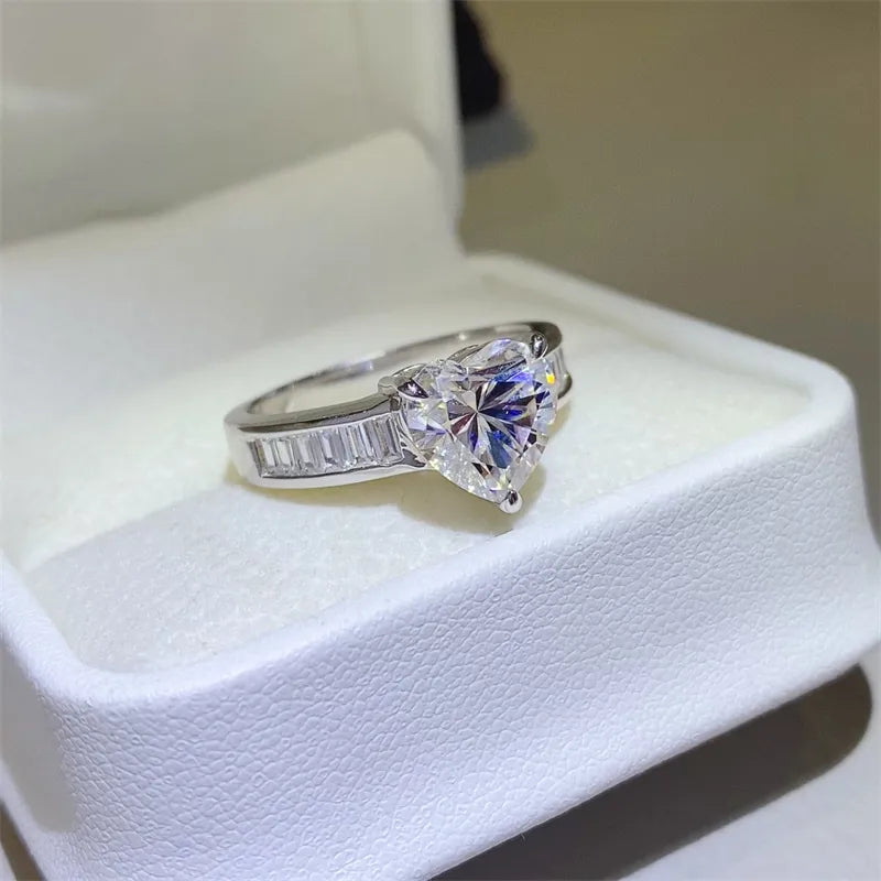 Silver heart-cut moissanite ring with baguette accents on a sterling silver band