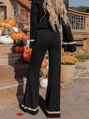 Black knit flare pants with contrast trim on bell sleeves and hem