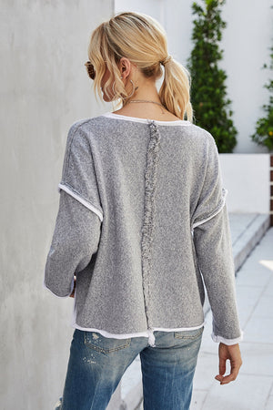 Grey acrylic knit sweater with contrast trim and distressed back seam detail.