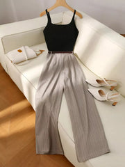 Chic sleeveless top and pinstripe wide-leg pants set in dark gray, styled with a white handbag and heels.