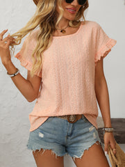 Peach eyelet knit blouse with ruffled short sleeves and a round neckline.
