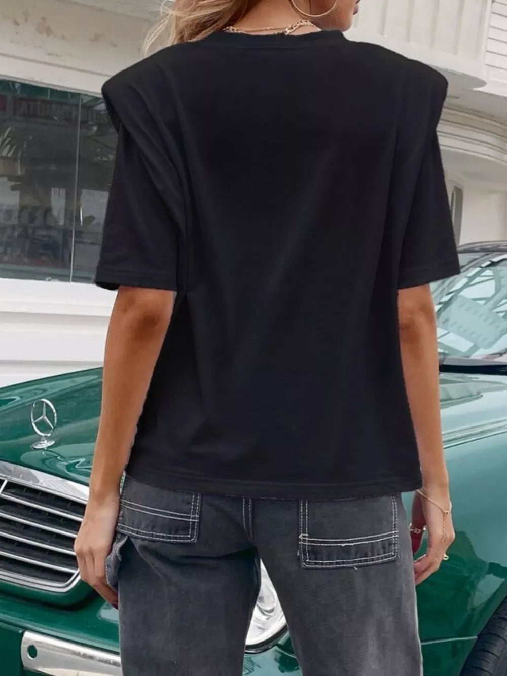 Black graphic t-shirt with padded shoulders and round neck.