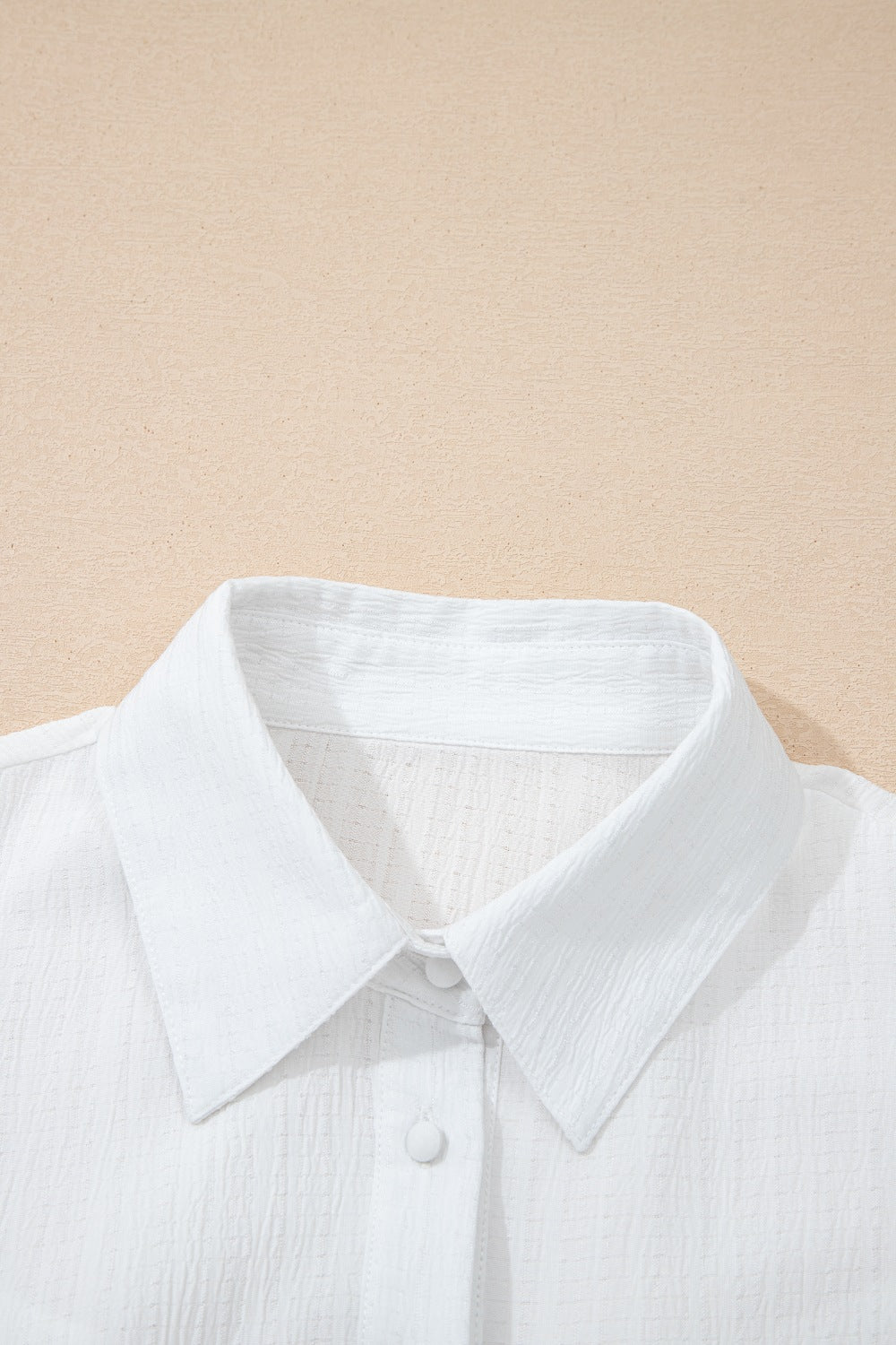 White crinkled texture button-down shirt with classic collar and button detail.