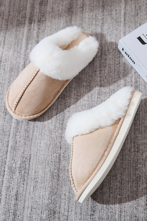 Beige suede house slides with white shearling trim and decorative stitching.