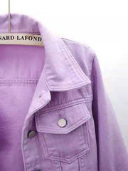 Lavender denim trucker jacket with button-flap chest pockets and collar detail.
