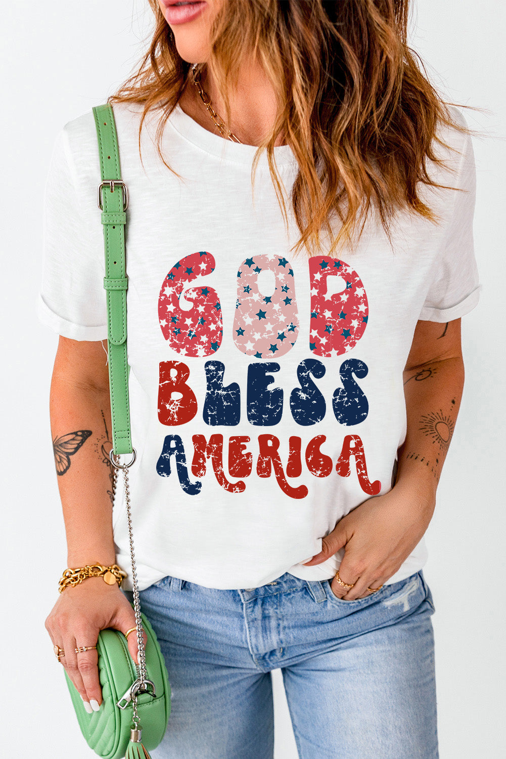 White graphic tee with distressed "God Bless America" text in red, white, and blue stars pattern.