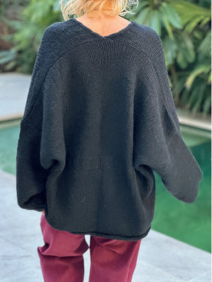Black oversized knit cardigan with V-neck and relaxed fit, showing back detail.