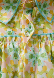 Yellow green floral ruffle yoke button-down blouse with blue trim and button detail.