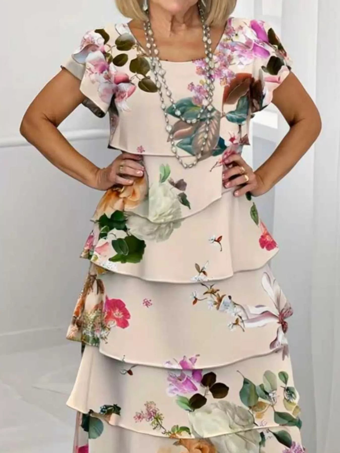 Ruffled tiered maxi dress in tan with a floral print, flutter sleeves, and square neckline.