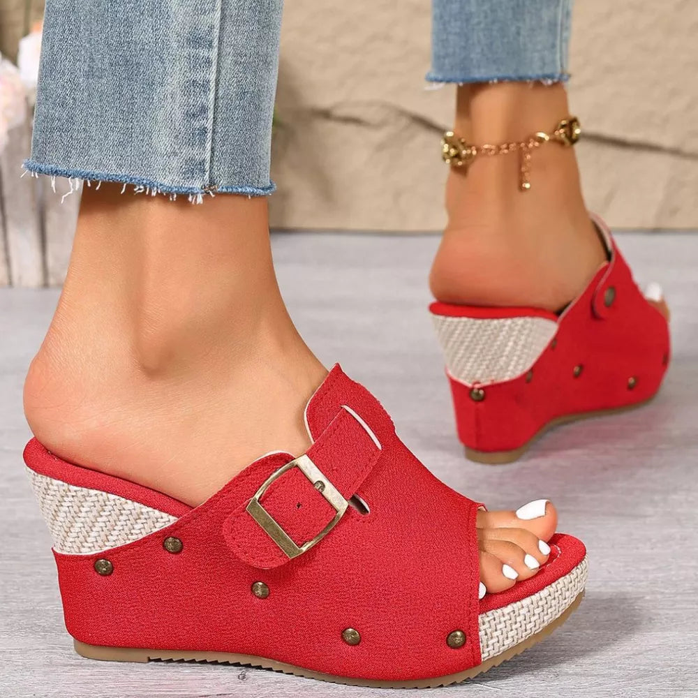 Red wedge sandals with decorative accents and buckle detail.