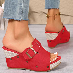 Red wedge sandals with decorative accents and buckle detail.