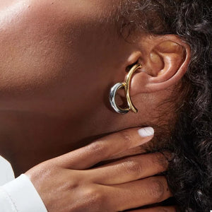 Intertwined two-tone C-hoop earrings in gold and silver metal with a contemporary design.