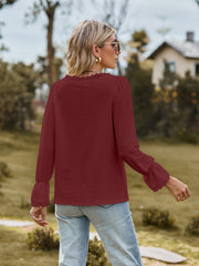 Wine textured blouse with lace trim neckline and ruffled cuffs.