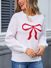 White knit sweater with red bow graphic, crew neck, long sleeves.