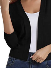 Black cropped knit cardigan with elbow sleeves and open front, worn over a white tank top.