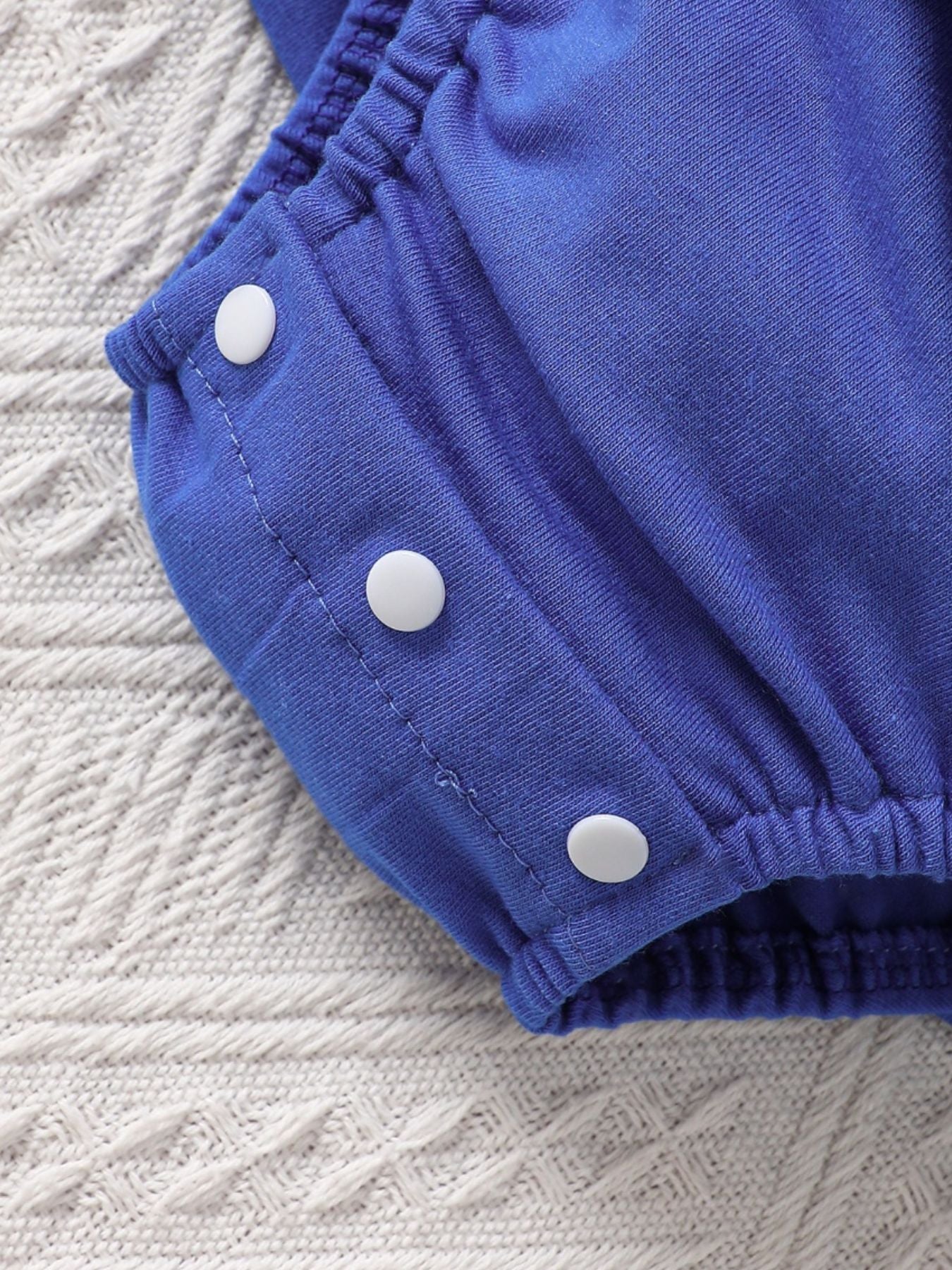 Sky blue cotton baby romper with ruffle sleeves and snap closures
