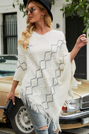 White knit poncho with geometric pattern and pearl embellishments, V-neck, fringed hem