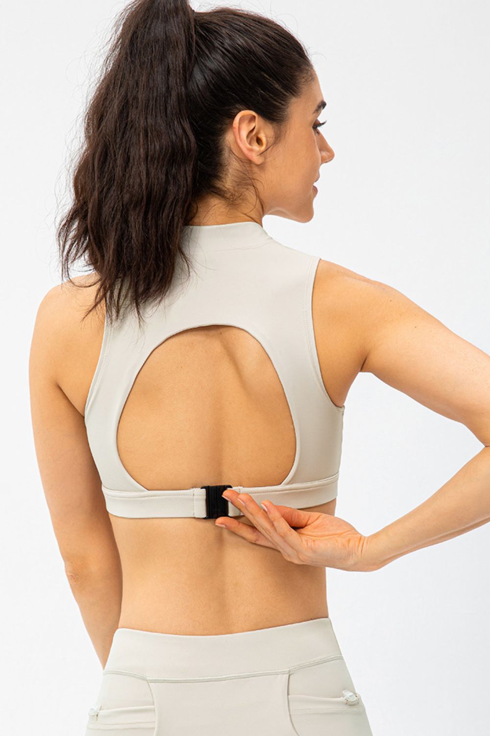 High-neck active crop top in light gray with back cutout and buckle detail
