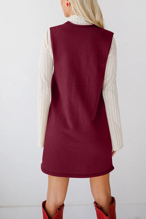 Burgundy sweater dress with deep V-neck and pockets, layered over a cream ribbed long sleeve top.