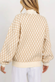 Cream diamond knit sweater with balloon sleeves and mock neck.