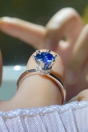 Blue moissanite ring with six-prong setting and diamond band