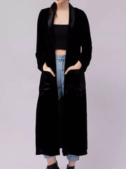 Black velvet longline trench coat with satin lapels and pockets.