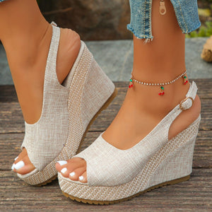 Beige woven espadrille wedge sandals with peep toe and slingback strap.