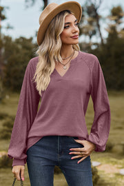 Burgundy waffle knit raglan top with V-neck and eyelet sleeves.