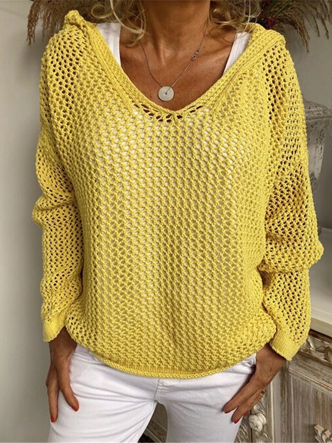 Yellow open-knit slouchy hooded sweater with V-neck and long sleeves.