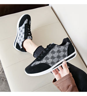 Black lace-up round toe sneakers with a patterned fabric and suede details.