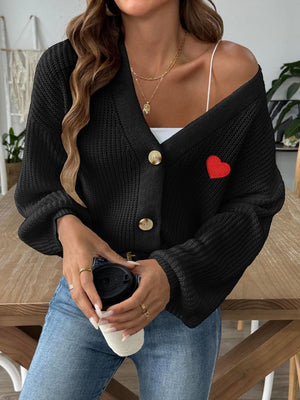 Black buttoned cardigan with balloon sleeves and red heart appliqué detail.