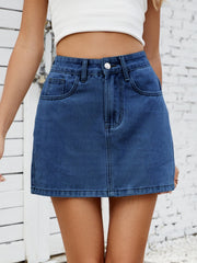 Classic denim mini skirt in medium blue with front pockets and button closure.
