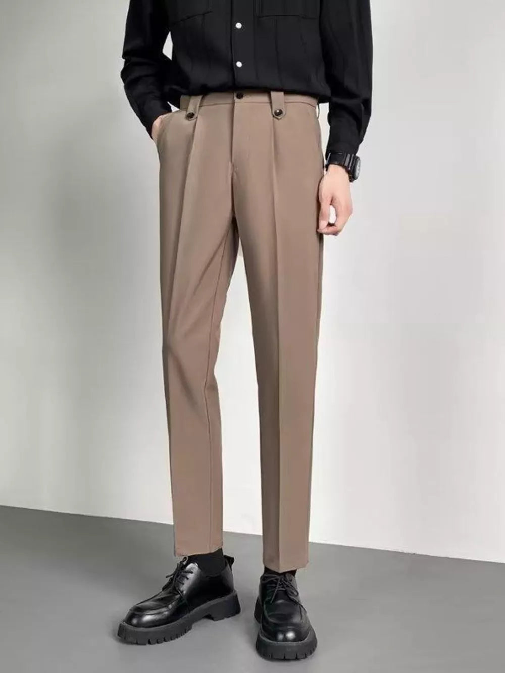Men's taupe ankle-length slim fit trousers with double button waist detail.