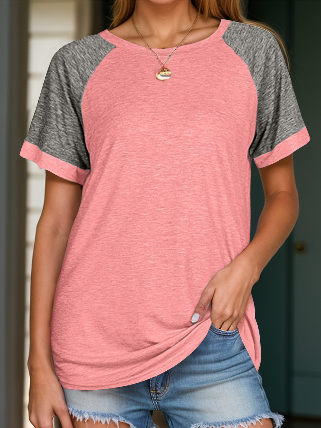Raglan sleeve tee in pink with gray sleeves and crew neck.