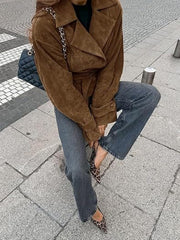 Brown faux suede tie-waist jacket with wide lapels and button cuffs, styled with jeans.