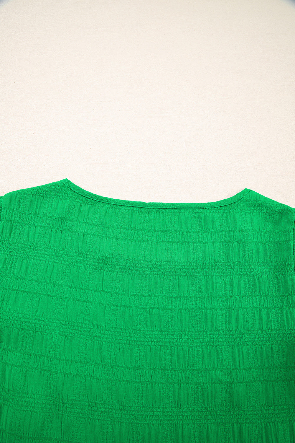 Green textured crew neck blouse with smocked detail and ruffle sleeves.